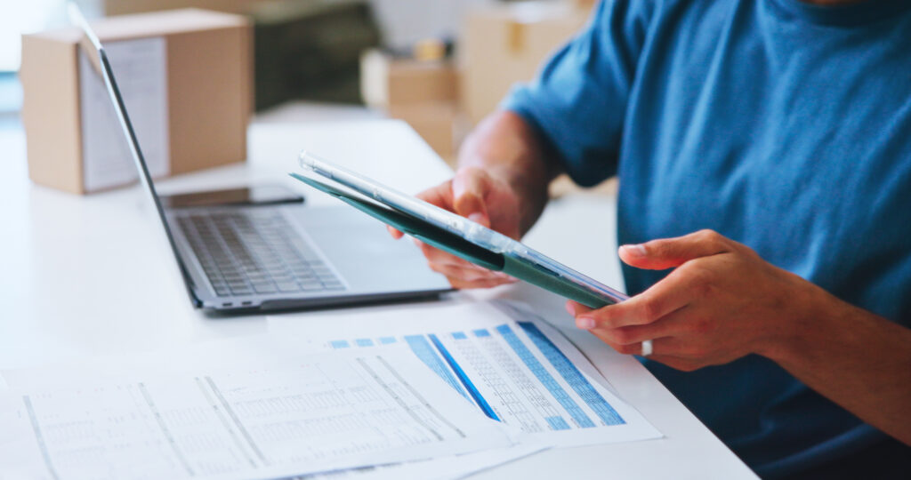 Small business office and person with tablet boxes or planning for distribution of order or ecommerce Closeup entrepreneur and tech for dropshipping with documents hands or stock for online shop